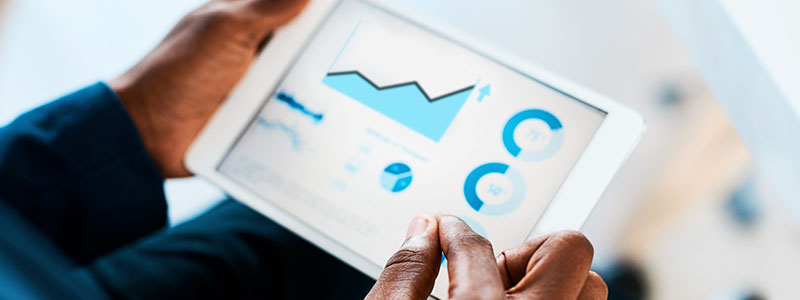 Hands holding tablet showing graphs