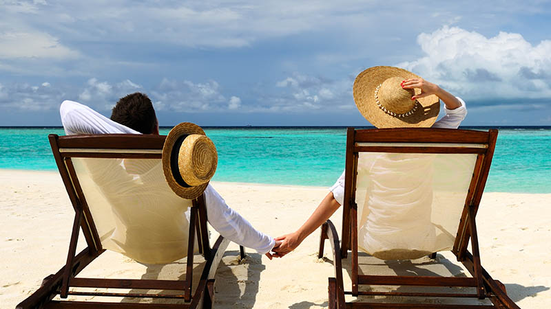 A couple sitting in chairs on a beach