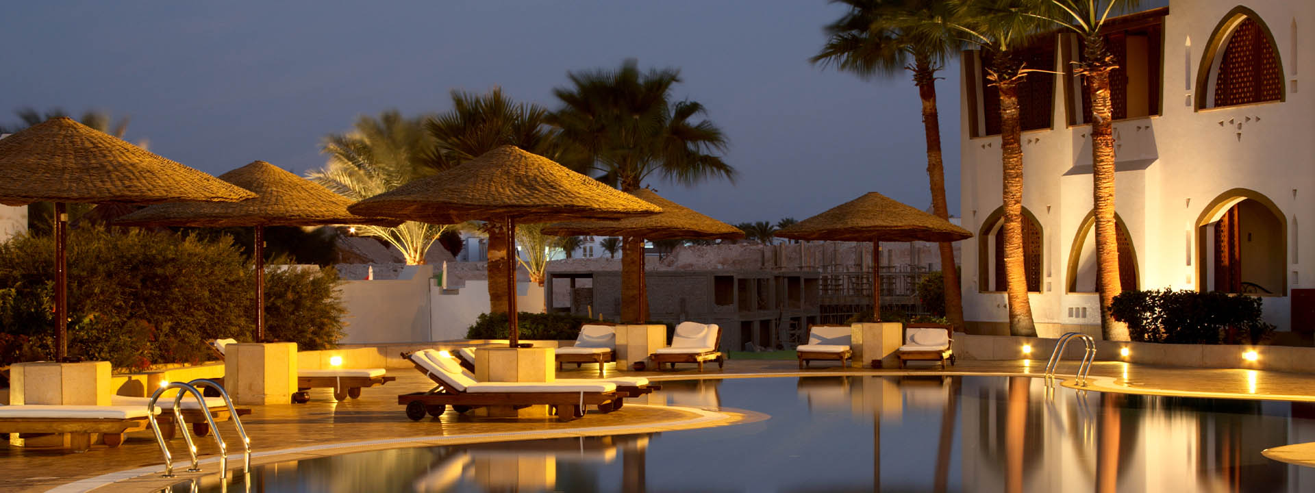 A pool with umbrellas and lounge chairs