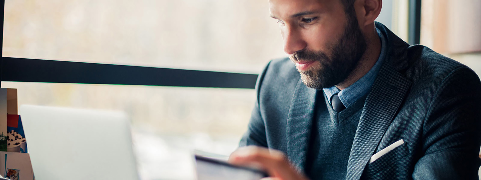 a person in a suit looking at a tablet