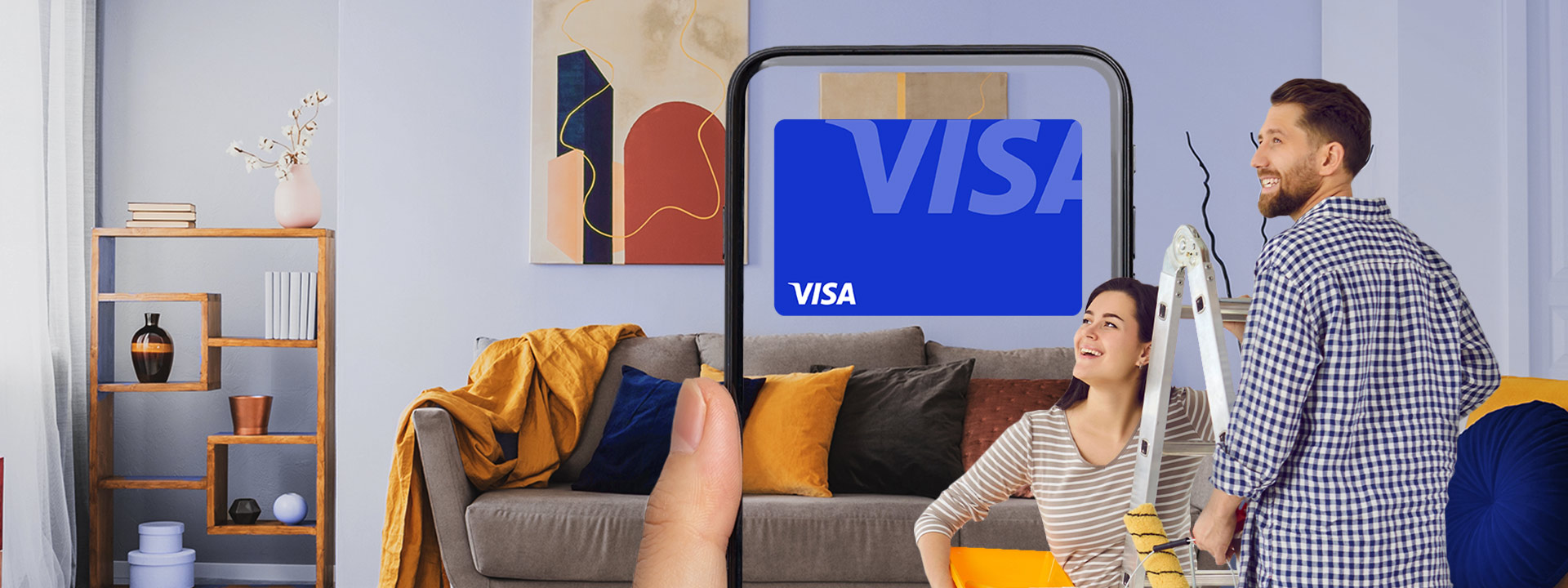 A person holds a smartphone displaying a virtual Visa card in front of a couple painting and decorating a modern living room.