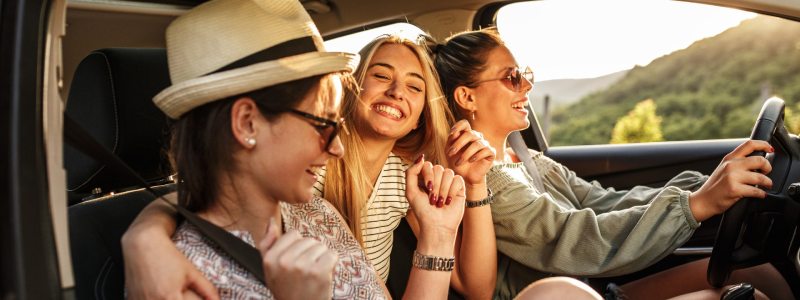 Three women laughing in a car