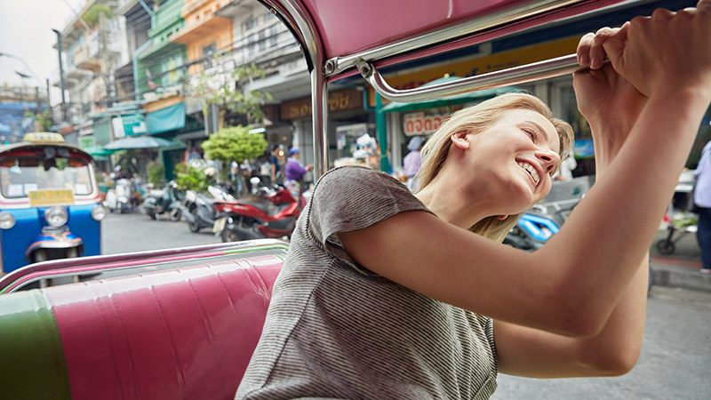 Woman sticking her head out a car window and smiling.